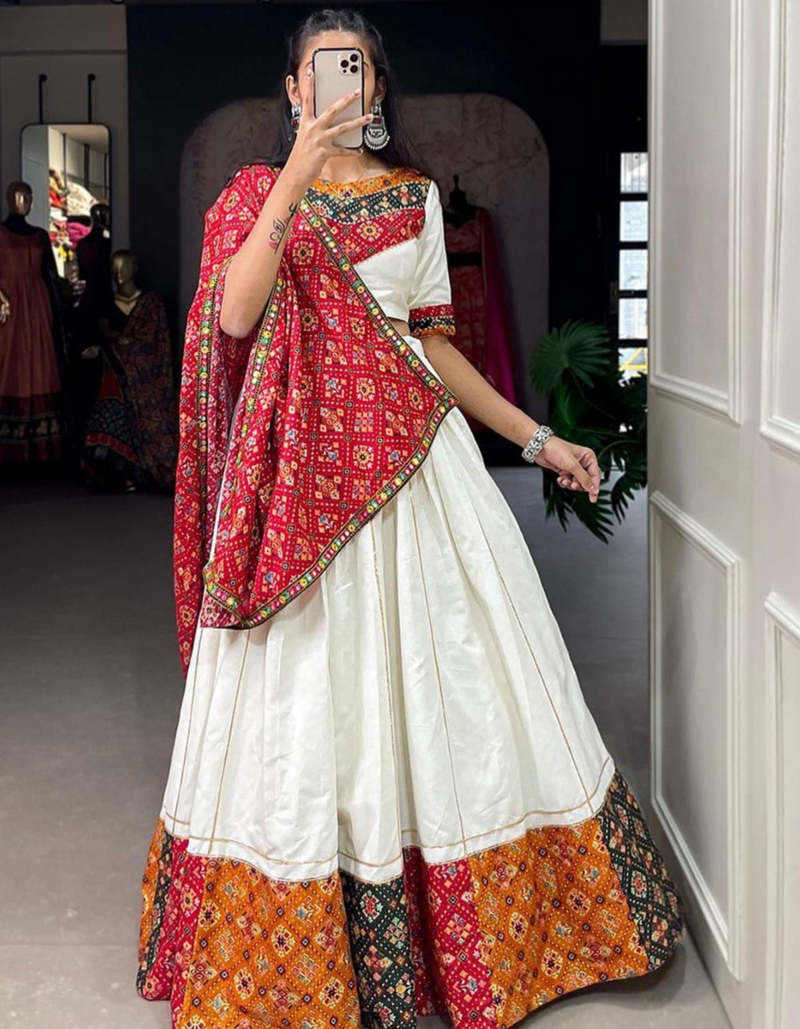 This white lehenga and choli ensemble, paired with a bold red dupatta