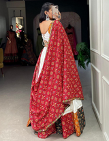 This white lehenga and choli ensemble, paired with a bold red dupatta