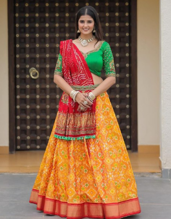 Yellow lehenga paired with a bold green choli and complemented by a striking red dupatta