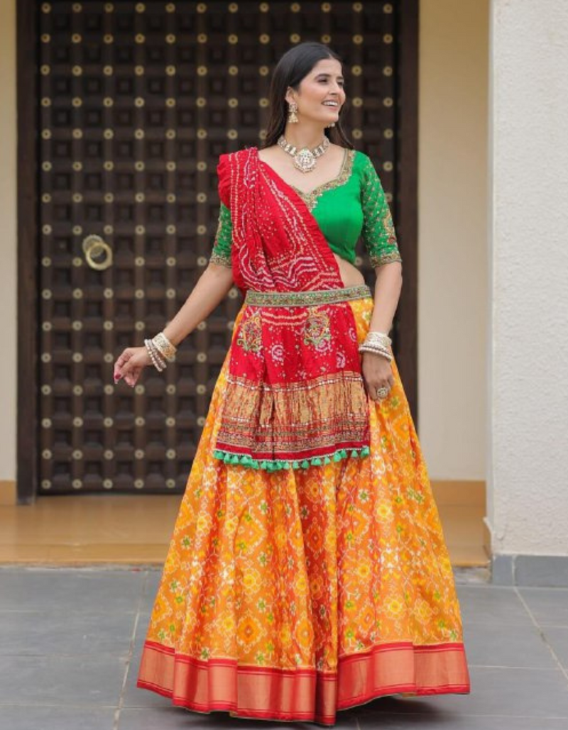 Yellow lehenga paired with a bold green choli and complemented by a striking red dupatta