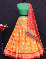 Yellow lehenga paired with a bold green choli and complemented by a striking red dupatta