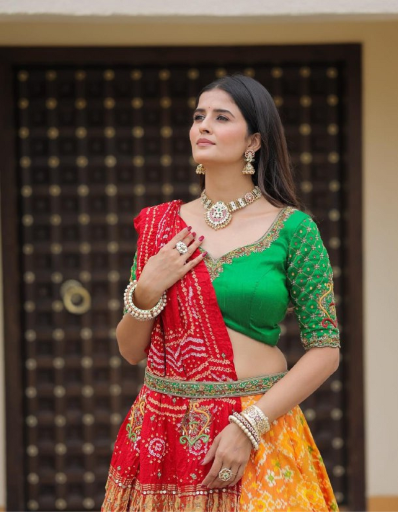 Yellow lehenga paired with a bold green choli and complemented by a striking red dupatta