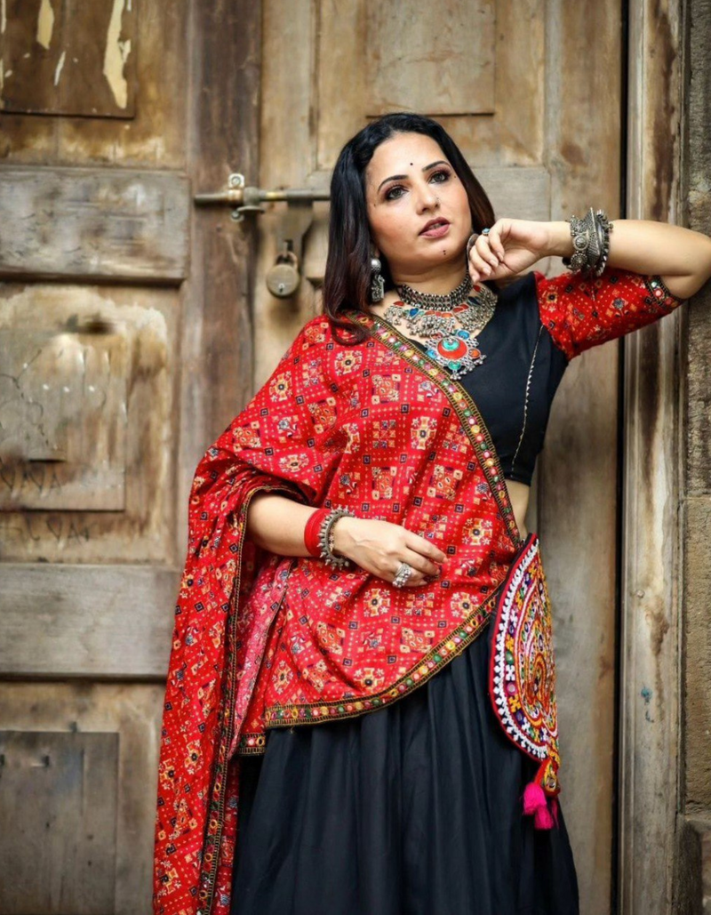 Black lehenga choli paired with a vibrant red dupatta, blending tradition