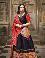 Black lehenga choli paired with a vibrant red dupatta, blending tradition