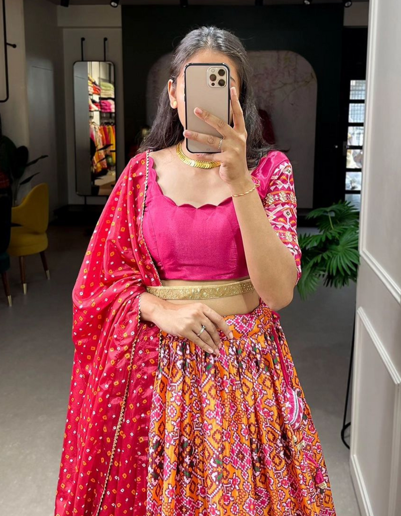 A light yellow lehenga, pink choli, and vibrant red dupatta