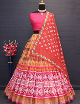 A light yellow lehenga, pink choli, and vibrant red dupatta